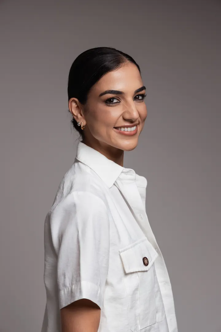 Retrato da Dra. Luciana Paschoal, geriatra, de camisa branca, sorrindo